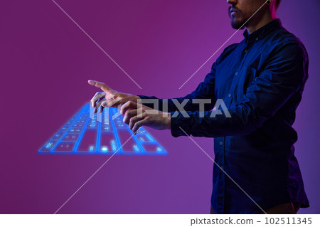 Businessman, programmer typing on virtual, digital, wireless keyboard. Innovation, cyberspace, holographic image of computer tool 102511345