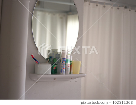 牙膏在慵懶的午後光線中倒映在洗臉盆的鏡子裡 102511368