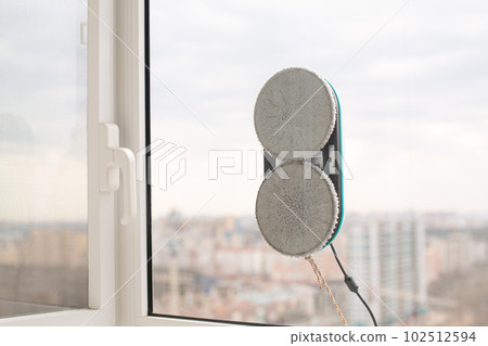 Smart vacuum cleaner washing windows. Home appliance concept 102512594