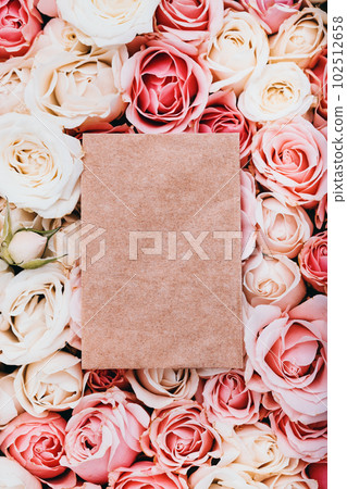 Empty craft paper with copy space on fresh roses background, top view 102512658