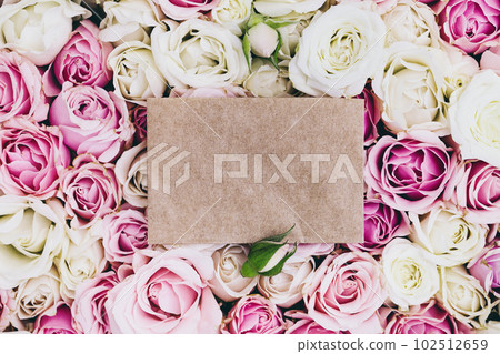Empty craft paper with copy space on fresh roses background, top view 102512659
