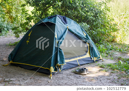 Sport shoes near a tent in camping forest 102512779