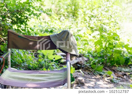 Empty camping chair and panama hat standing outdoors. Empty camping chair and panama hat standing outdoors. 102512787