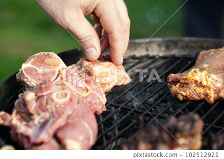 Cooking different meat on barbecue. Grilled and roasted lamb steaks on bbq. Take one piece Cooking different meat on barbecue. Grilled and roasted lamb steaks on bbq. Take one piece 102512921