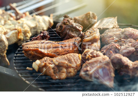 Cooking different meat on barbecue. Grilled and roasted lamb steaks on bbq Cooking different meat on barbecue. Grilled and roasted lamb steaks on bbq 102512927