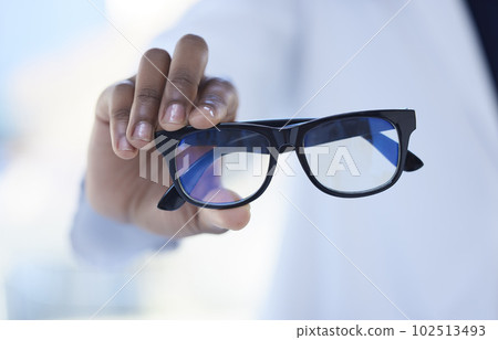 Glasses, optometry and hands of a doctor for vision, eyesight checkup and giving prescription eyewear. Recommendation, help and an optometrist with eyeglasses, helping with choice and showing Glasses, optometry and hands of a doctor for vision, eyesight checkup and giving prescription eyewear. Recommendation, help and an optometrist with eyeglasses, helping with choice and showing 102513493