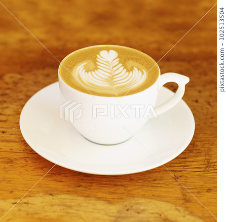 Coffee, cafe and latte art in a cup on wooden table background in restaurant to drink espresso with foam. Retro, diner and mug with saucer in kitchen with vintage design during morning breakfast. Coffee, cafe and latte art in a cup on wooden table background in restaurant to drink espresso with foam. Retro, diner and mug with saucer in kitchen with vintage design during morning breakfast. 102513504