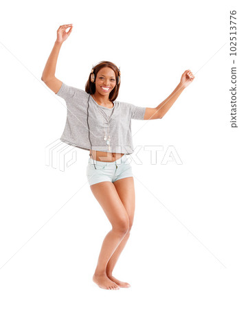 Feeling the music. Portrait of a smiling ethnic woman dancing in her pajamas with her earphones on. 102513776