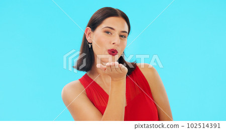 Face, woman and blowing kiss on blue background, studio and color backdrop of love, care and flirting hands. Portrait of happy model, air kissing and smile for happiness, emoji or valentines day date 102514391