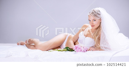 Portrait, sexy and bride with lingerie, luxury and happiness against a grey studio background. Face, female person and happy woman with underwear, flowers and honeymoon with joy, bedroom and beauty Portrait, sexy and bride with lingerie, luxury and happiness against a grey studio background. Face, female person and happy woman with underwear, flowers and honeymoon with joy, bedroom and beauty 102514421