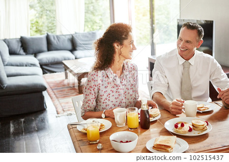 Breakfast tastes ten times tastier when shared with your dearest. a mature couple having breakfast together at home. 102515437