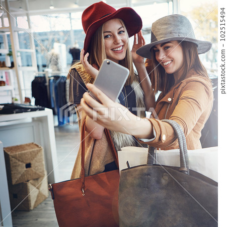 This is the one. two young girlfriends snapping selfies while out on a shopping spree. 102515494