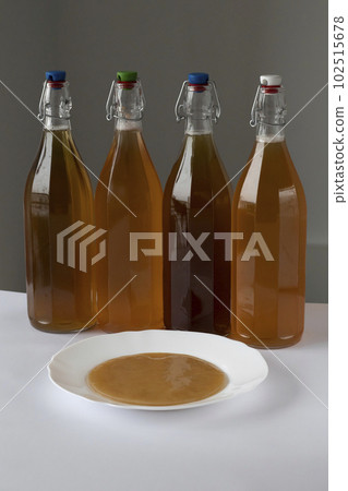 Homemade fermented tea mushroom kombucha drink in bottles. Probiotic, symbiotic superfoods. Non-alcoholic fizzy cocktail, antioxidant. Homemade fermented tea mushroom kombucha drink in bottles. Probiotic, symbiotic superfoods. Non-alcoholic fizzy cocktail, antioxidant. 102515678