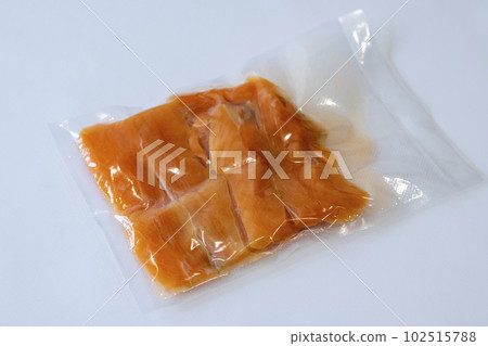 Vacuum packaging of salmon fillet fish for long term storage or Sous vide cooking. Using a vacuum packer for long term food storage. Top view. 102515788