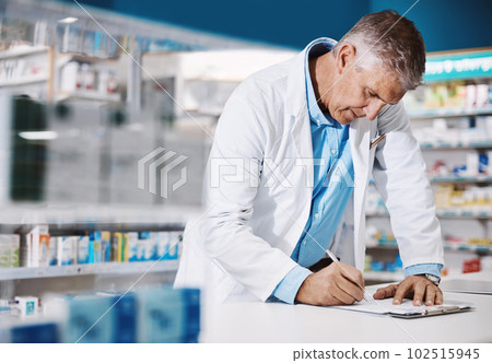 Checking a big prescription. a male pharmacist writing on a clipboard in a drugstore. 102515945