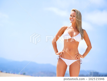 Sea, sun and summer fun. A gorgeous young blonde woman enjoying summer on the beach. 102515946