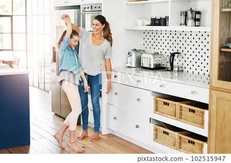 The moments that make life meaningful. a happy mother and daughter playfully dancing together at home. 102515947