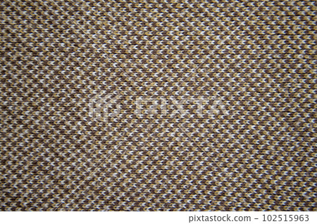 Knitted pattern of brown, white and orange yarns. Brown knitted fabric. Knitted texture.  102515963
