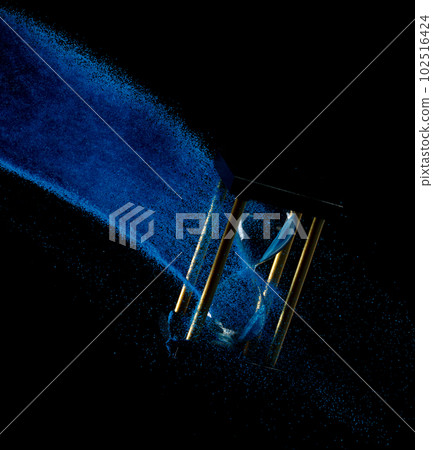Hourglass fly float in mid air. Life is blue sand around hourglass to add more limited time. Deadline extended time management hope concept hour glass. Black background shadow life clock passing by Hourglass fly float in mid air. Life is blue sand around hourglass to add more limited time. Deadline extended time management hope concept hour glass. Black background shadow life clock passing by 102516424