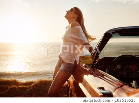 Ocean air and wind in your hair. a happy young woman enjoying a summers road trip. 102516525
