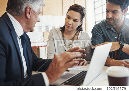 Getting all the facts before they make a decision. a young married couple consulting with their financial advisor in his office. 102516579