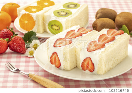 Strawberry, kiwi and orange fruit sandwich on a white round plate 102516746