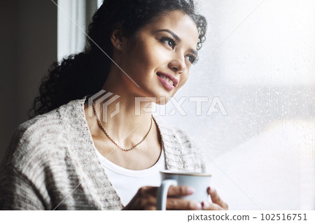 Life is so much better when youre relaxing. an attractive young woman relaxing at home with a cup of coffee. 102516751