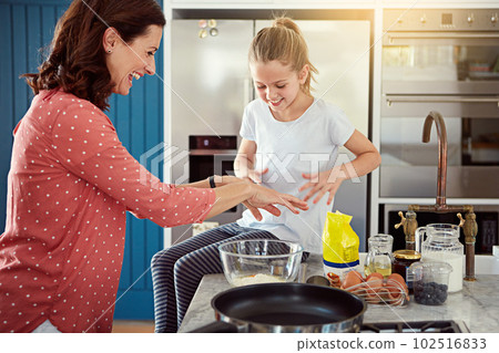 Shes a lovely little helper. a mother baking with her daughter in the kitchen. Shes a lovely little helper. a mother baking with her daughter in the kitchen. 102516833