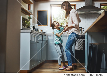 They just love to dance. a mother playing with her little daughter in the kitchen at home. 102516969