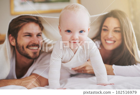 My parents and me. a young couple and their baby daughter in the bedroom. 102516979