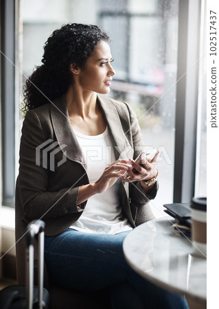 Keeping in touch with clients all around the globe. a young businesswoman using a cellphone while waiting for her flight in an airport lounge. Keeping in touch with clients all around the globe. a young businesswoman using a cellphone while waiting for her flight in an airport lounge. 102517437
