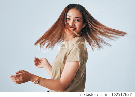 Portrait, beauty and hair with a woman in studio on a gray background for keratin treatment or haircare. Salon, shampoo and hairstyle with an attractive young female posing to promote natural care 102517657