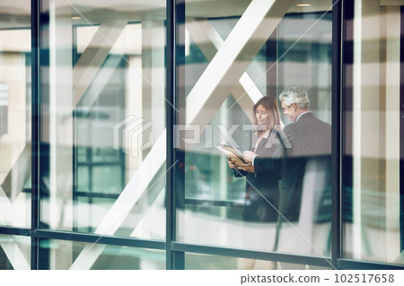 They know all there is to know about business. a businessman and businesswoman having a discussion in a modern office. 102517658