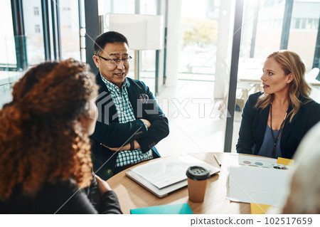 Business has been running well under his expertise. a group of businesspeople having a meeting in an office. 102517659