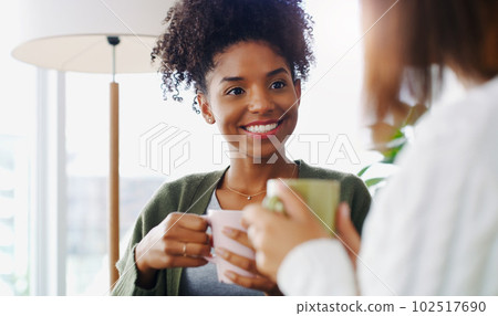 Caffeine and friends is all you need. two attractive young women sitting together and drinking coffee while at home during the day. 102517690