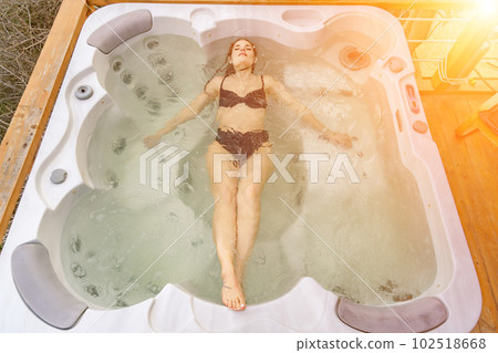 Take time for yourself. Outdoor swimsuit with mountain and sea views. A woman in a black swimsuit lies in the hotel pool. Shot of a young woman relaxing in the pool. Take time for yourself. Outdoor swimsuit with mountain and sea views. A woman in a black swimsuit lies in the hotel pool. Shot of a young woman relaxing in the pool. 102518668
