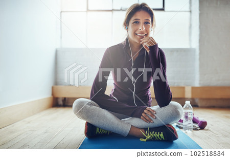 Im closer than ever to my fitness goals. Portrait of an attractive young woman listening to music while working out at home. Im closer than ever to my fitness goals. Portrait of an attractive young woman listening to music while working out at home. 102518884
