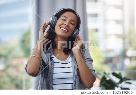 Some songs leave you with goosebumps in a good way. a young woman wearing headphones while listening to music at home. 102519266