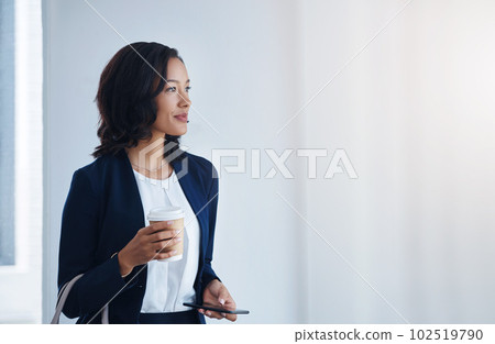 Making moves that will have her soar in her career. a young businesswoman using a cellphone in an office. 102519790