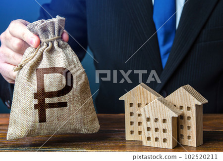 Russian ruble money bags and residential buildings figures. Investments in real estate and construction industry. Bank offer of mortgage loan. Rental business. Sale of housing. Municipal budget. Taxes 102520211