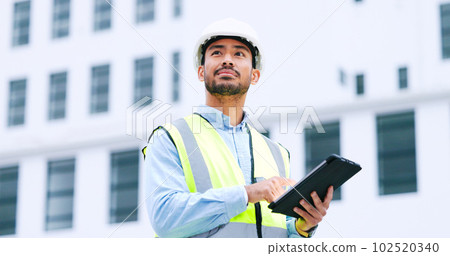 Thinking architect browsing digital tablet, analysing building plans for city planning, residential or office development. Architectural engineer or contractor checking online blueprint on technology 102520340