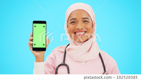 Green screen, phone and nurse isolated on blue background with medical mobile app, tracking marker and healthcare mockup. Happy islamic doctor or woman face with cellphone product placement in studio 102520385