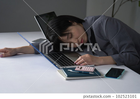 Businesswoman sleeping tired after working overtime in office 102523101