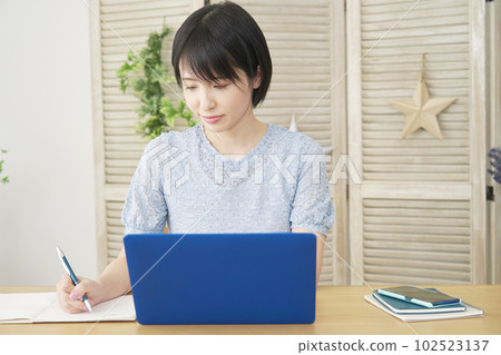 在客廳裡用筆記本電腦學習的女人 在客廳裡用筆記本電腦學習的女人 102523137