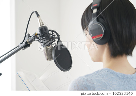 Female narrator narrating in studio Female narrator narrating in studio 102523140