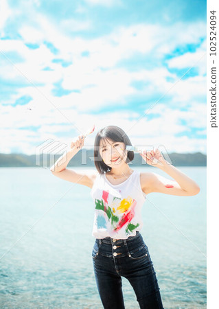 美麗的女人在藍天下用五顏六色的顏料作畫 102524094