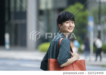 A man in his 20s standing on a street corner A man in his 20s standing on a street corner 102524449