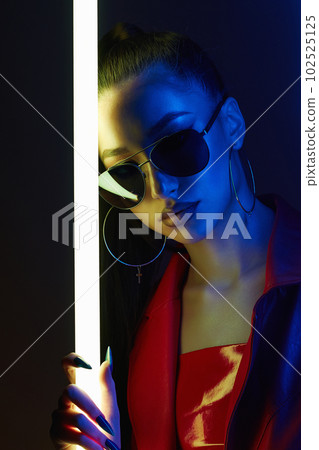 beautiful young woman with neon lamp. Pretty girl in sunglasses 102525125