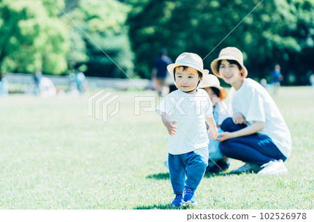 Parents and children playing in the park. 102526978