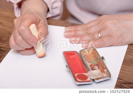 [Woman stamping the stamp with case] 102527926